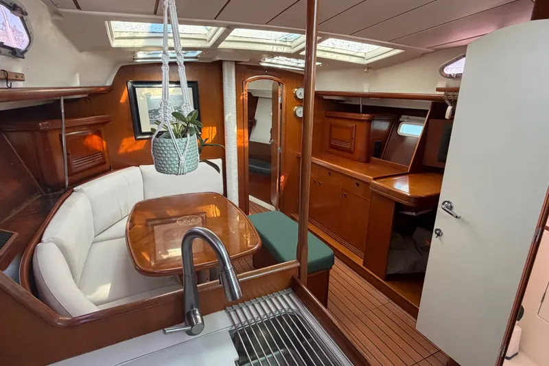 Slide: The Image of Interior of 2003 Beneteau Oceanis 393 yacht with elegant wood finish and cozy seating area. - 12