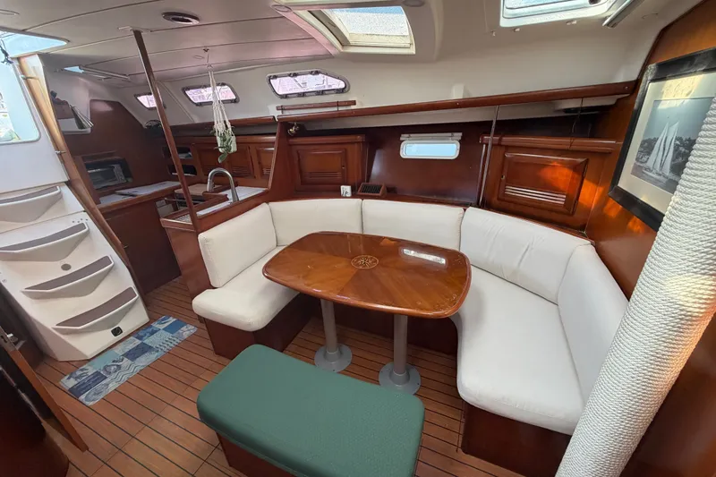 Slide: The Image of Interior of 2003 Beneteau Oceanis 393 yacht with cozy seating and wooden table. - 29