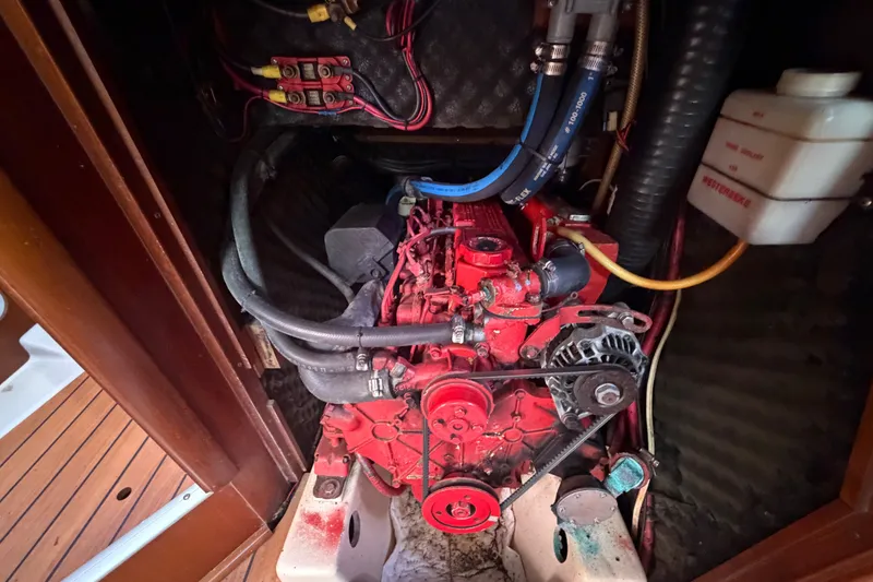 Slide: The Image of Engine compartment of a 2003 Beneteau Oceanis 393 sailboat, featuring red engine components. - 32