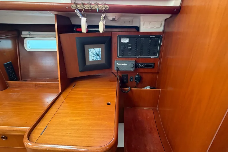 Slide: The Image of Interior of 2003 Beneteau Oceanis 393 sailboat with navigation panel and wooden cabinetry. - 16
