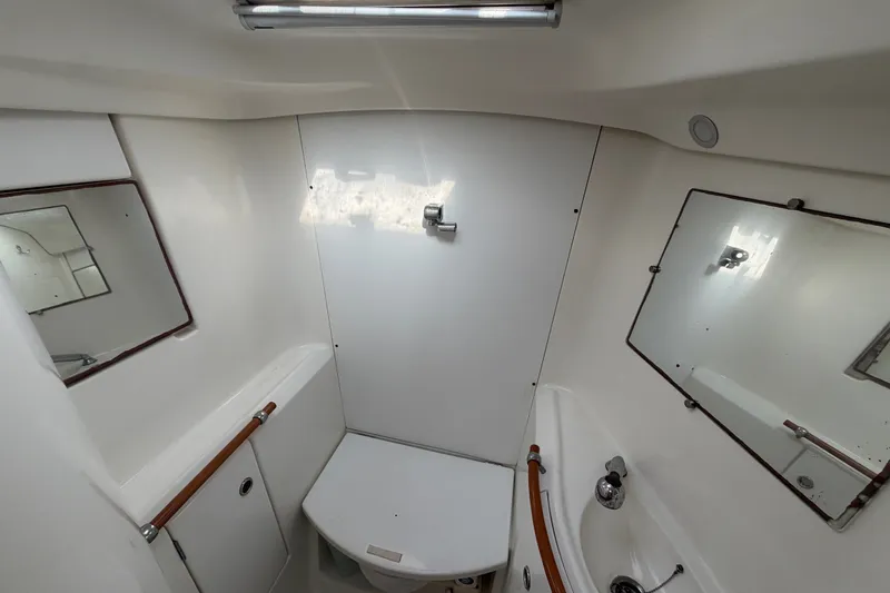 Slide: The Image of Bathroom interior of a 2003 Beneteau Oceanis 393 yacht, featuring mirrors and compact fixtures. - 25