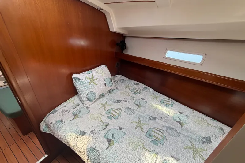 Slide: The Image of Cozy cabin interior of 2003 Beneteau Oceanis 393 sailboat with nautical-themed bedding. - 26