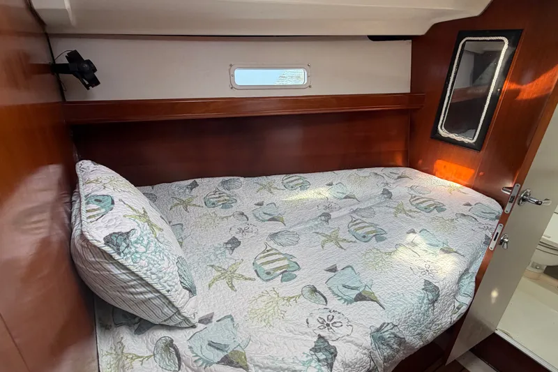 Slide: The Image of Cozy cabin interior of 2003 Beneteau Oceanis 393 sailboat with nautical-themed bedding. - 22