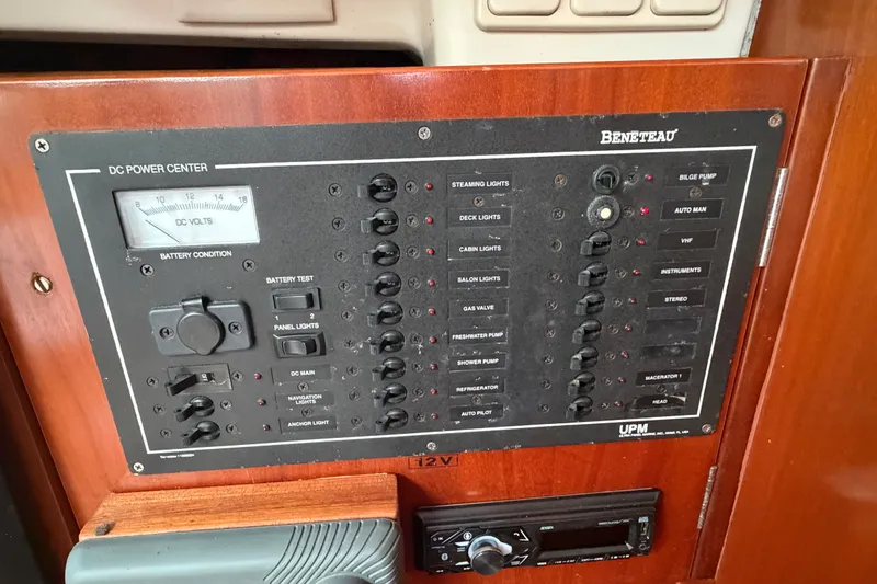 Slide: The Image of Control panel of a 2003 Beneteau Oceanis 393 sailboat, featuring various switches and gauges. - 17