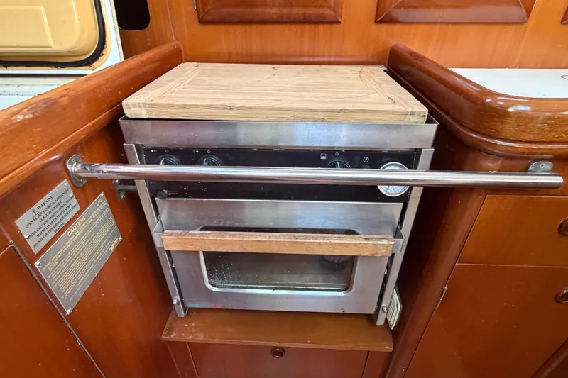 Slide: The Image of Galley oven in 2003 Beneteau Oceanis 393 sailboat interior, featuring wooden cabinetry. - 8