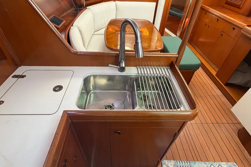 Slide: The Image of Interior of 2003 Beneteau Oceanis 393 yacht showing kitchen sink and seating area. - 13