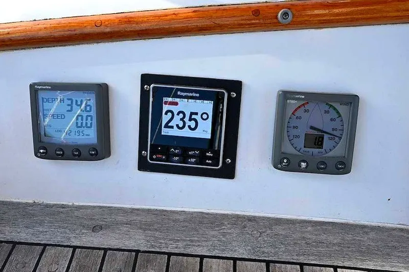 Slide: The Image of Boat dashboard with Raymarine instruments displaying depth, speed, and wind angle on a 1982 Passport Hoyt 45. - 17