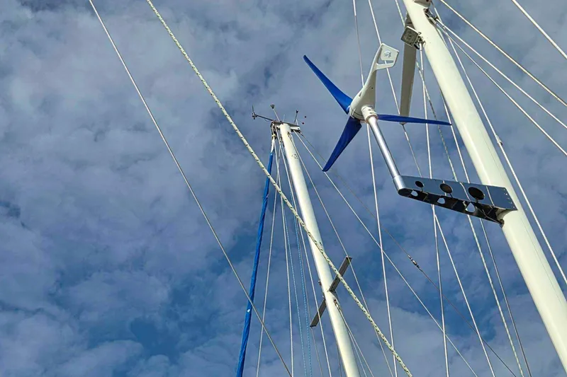 Slide: The Image of Sailboat masts with wind turbine against cloudy sky, Passport Hoyt 45, 1982 model. - 9