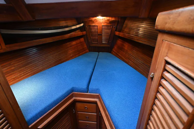 Slide: The Image of Cozy wooden cabin interior with blue cushions on a 1982 Passport Hoyt 45 sailboat. - 56