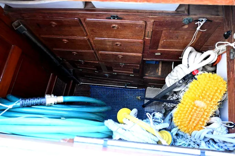 Slide: The Image of Storage compartment on a 1982 Passport Hoyt 45 boat with ropes and cleaning supplies. - 92