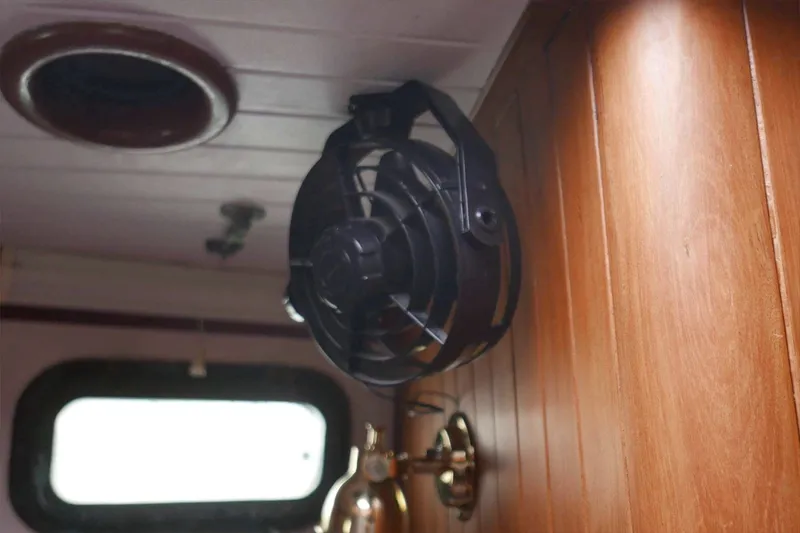 Slide: The Image of Vintage boat interior with a mounted fan, wooden paneling, and brass fixtures, Passport/Hoyt 45, 1982. - 83
