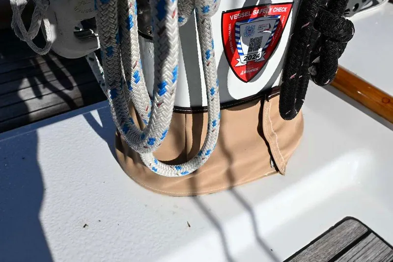 Slide: The Image of Sailboat deck with ropes and a 2024 vessel safety check sticker, Passport Hoyt 45, 1982 model. - 26