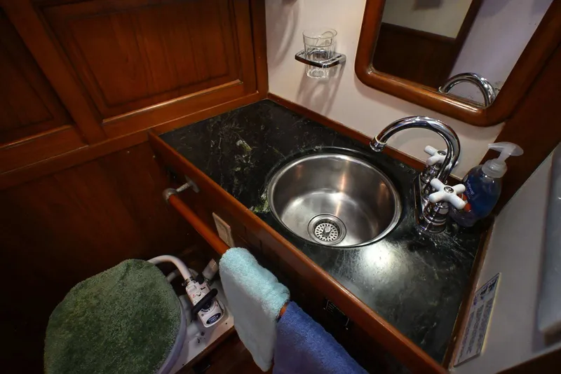 Slide: The Image of Compact boat bathroom with sink, faucet, and toilet in a 1982 Passport Hoyt 45 model. - 55