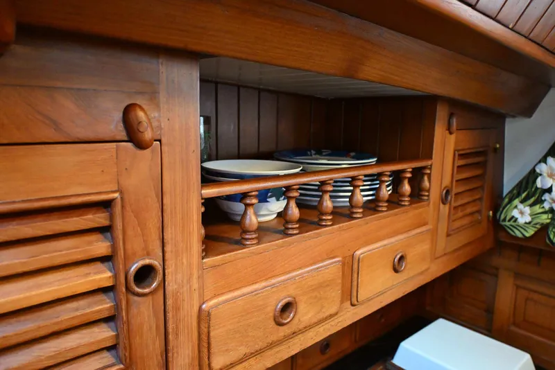 Slide: The Image of Wooden cabinet interior with plates, bowls, and drawers on a 1982 Passport Hoyt 45 yacht. - 72