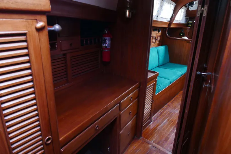 Slide: The Image of Interior of 1982 Passport Hoyt 45 yacht with wooden cabinetry and teal seating. - 58