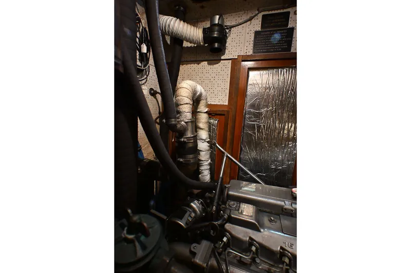 Slide: The Image of Engine room of a 1982 Passport Hoyt 45 sailboat with insulated pipes and machinery. - 85