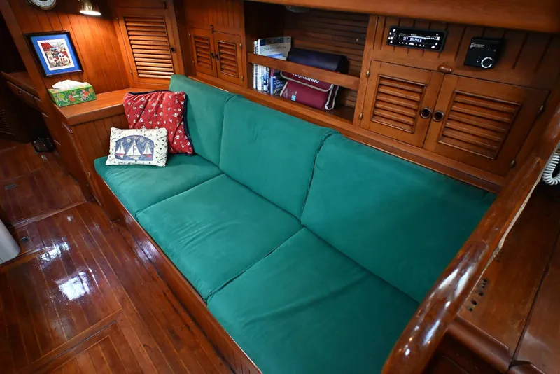 Slide: The Image of Cozy 1982 Passport Hoyt 45 yacht interior with green sofa and nautical-themed pillows. - 52