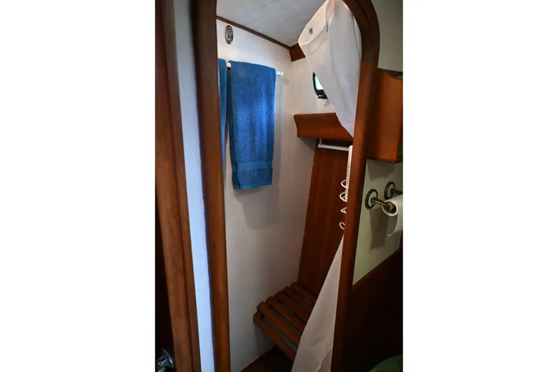Slide: The Image of Compact wooden bathroom interior of 1982 Passport Hoyt 45 sailboat with towel and shower. - 53