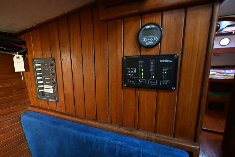 Slide: The Image of Wood-paneled interior of 1982 Passport Hoyt 45 yacht with control panels and blue seating. - 86