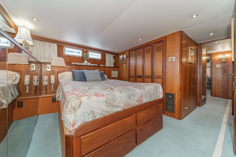 Slide: The Image of Luxurious 1971 Hatteras 53 Motor Yacht bedroom with wood paneling and elegant decor. - 20