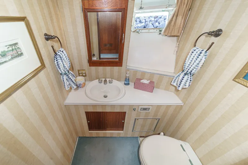 Slide: The Image of 1971 Hatteras 53 Motor Yacht bathroom with striped wallpaper and compact sink area. - 17