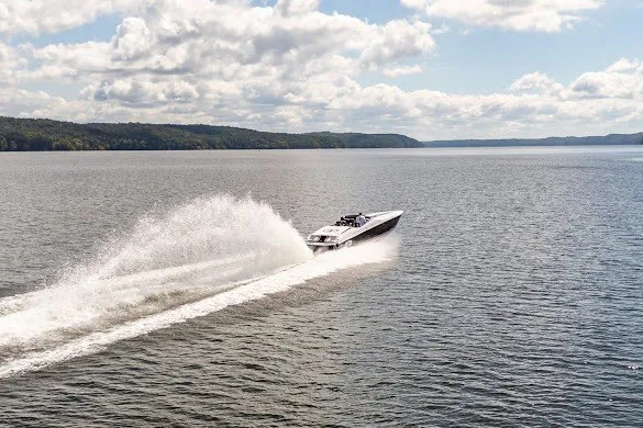 Slide: The Image of 2018 Cigarette 42X speedboat cruising on a scenic lake under a partly cloudy sky. - 5