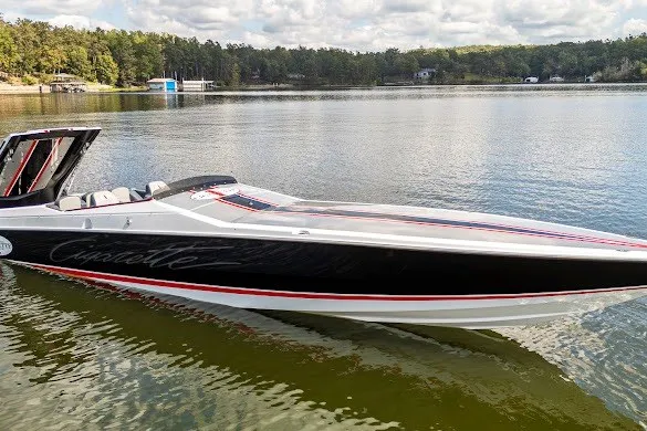 Slide: The Image of 2018 Cigarette 42X speedboat on a serene lake with forested shoreline. - 12
