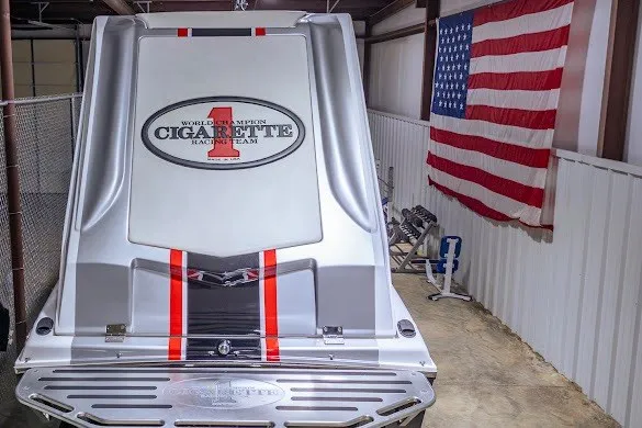 Slide: The Image of 2018 Cigarette 42X boat in garage with American flag backdrop. - 20