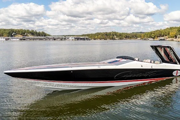 Slide: The Image of 2018 Cigarette 42X speedboat on a serene lake with lush green shoreline. - 16