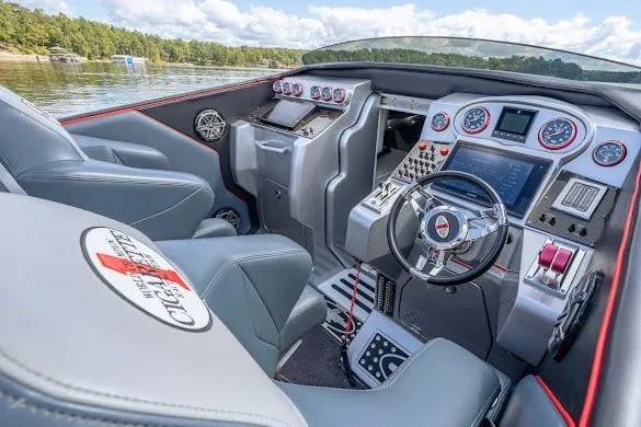 Slide: The Image of 2018 Cigarette 42X boat cockpit with advanced controls and luxurious seating on a serene lake. - 28