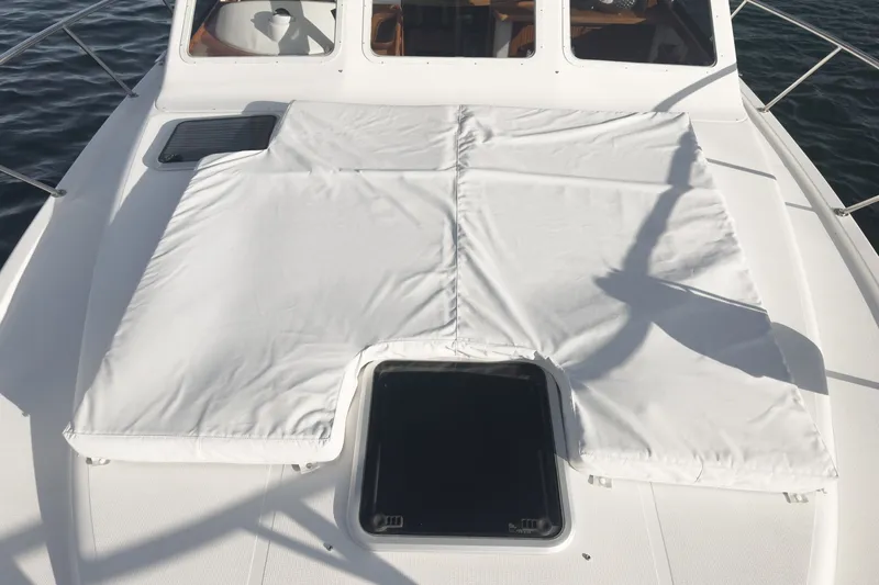 Slide: The Image of 1998 Riviera 34 Convertible boat deck with white cover and hatch. - 53