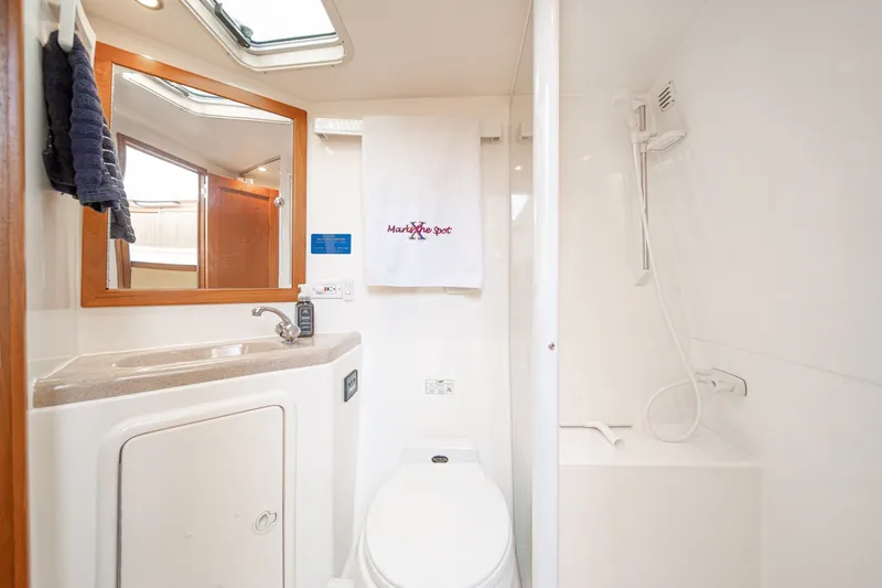 Slide: The Image of Bathroom interior of 1998 Riviera 34 Convertible yacht, featuring sink, mirror, and shower. - 47