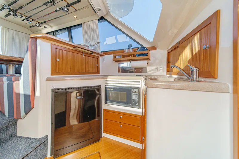 Slide: The Image of Interior of 1998 Riviera 34 Convertible yacht with kitchenette and fishing rods. - 42