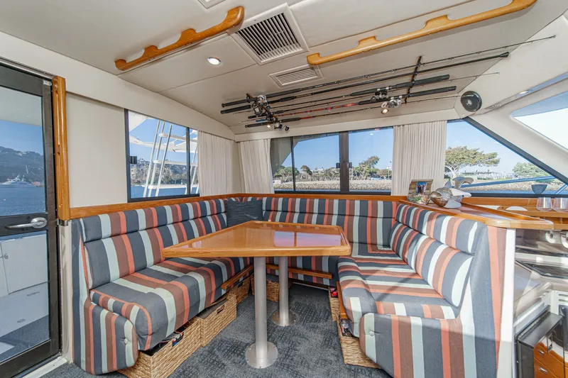 Slide: The Image of Interior of 1998 Riviera 34 Convertible yacht with striped seating and fishing rods. - 27