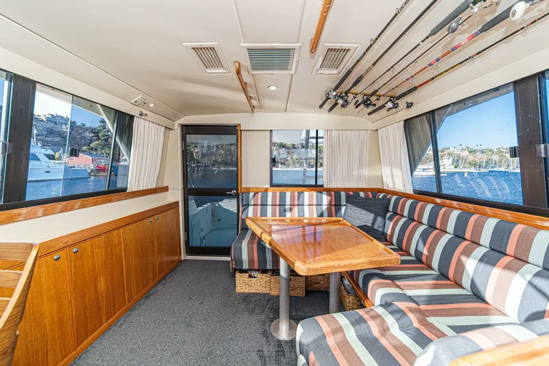 Slide: The Image of Interior of 1998 Riviera 34 Convertible yacht with striped seating and fishing rods. - 24
