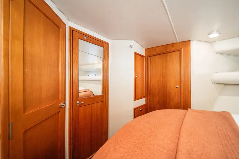 Slide: The Image of Interior of 1998 Riviera 34 Convertible yacht with wooden doors and cozy bedding. - 46