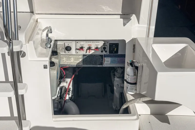Slide: The Image of Engine compartment of a 1998 Riviera 34 Convertible boat, featuring control panel and fire extinguisher. - 50