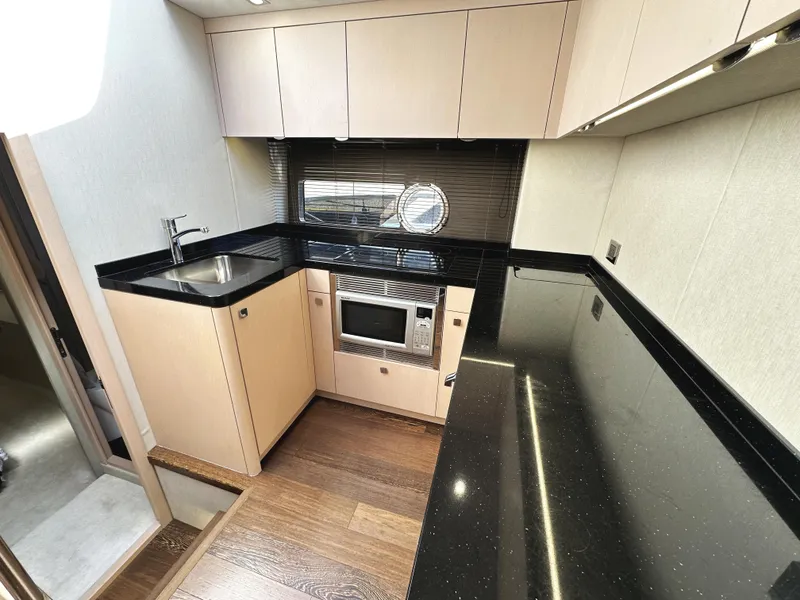 Slide: The Image of Modern kitchen interior of 2015 Sunseeker Predator 57 yacht with sleek black countertops. - 23