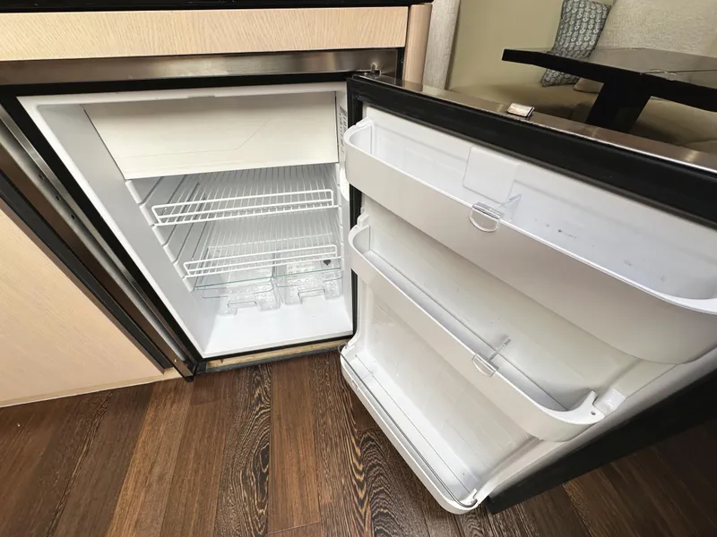 Slide: The Image of Open refrigerator inside a 2015 Sunseeker Predator 57 yacht, showcasing empty shelves. - 26