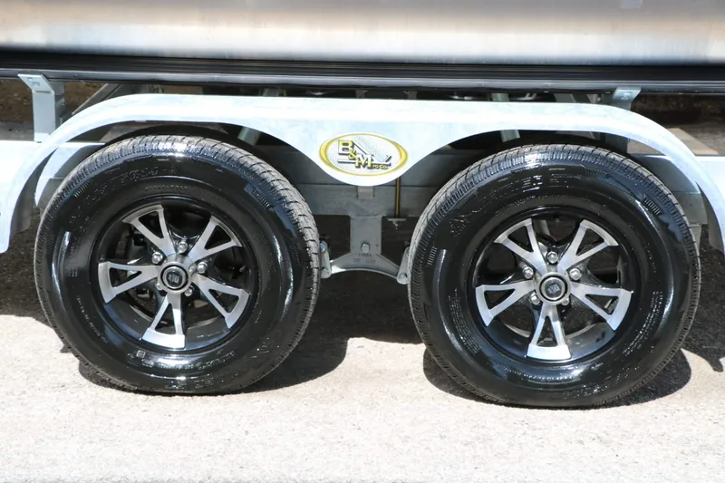 Slide: The Image of Close-up of two shiny black tires on a trailer with silver rims. - 34