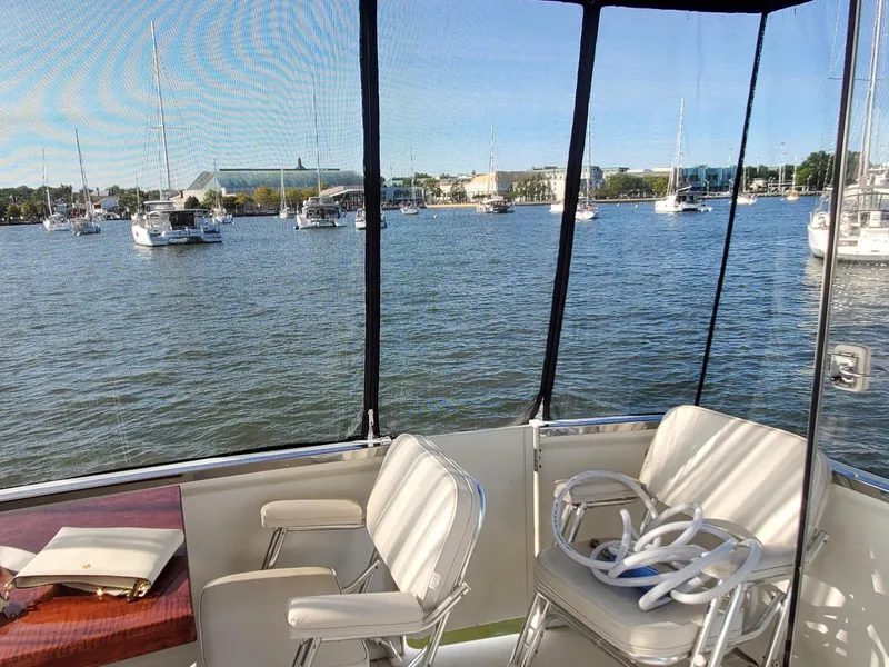 Slide: The Image of 2000 Carver 356 Aft Cabin Motor Yacht interior with marina view, featuring two chairs. - 18