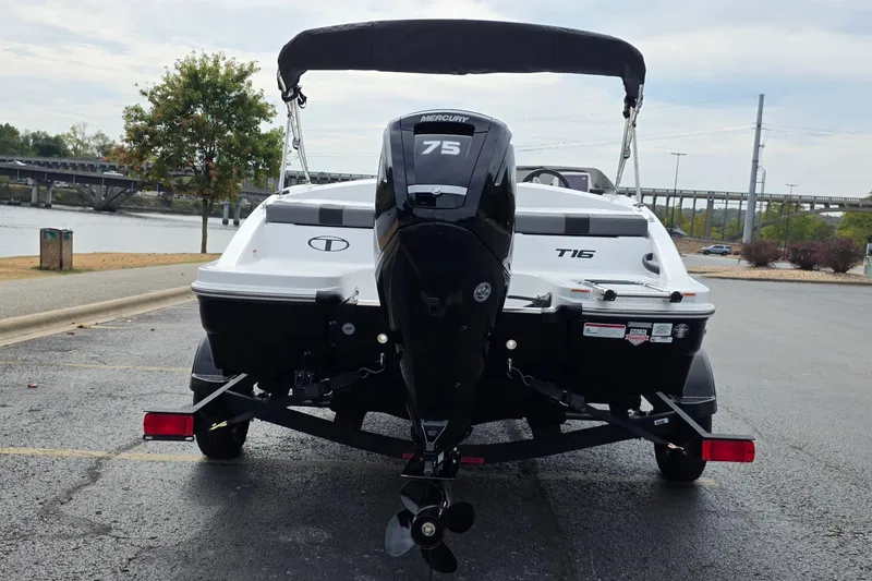 Slide: The Image of 2027 Tahoe T16 boat with Mercury 75 engine, parked near a river. - 5