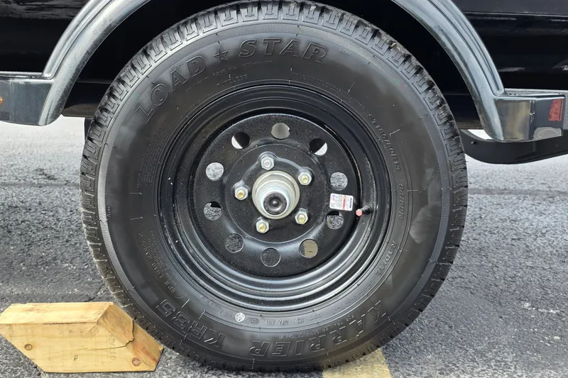 Slide: The Image of Close-up of a 2027 Tahoe T16 trailer wheel with Loadstar tire on asphalt. - 10