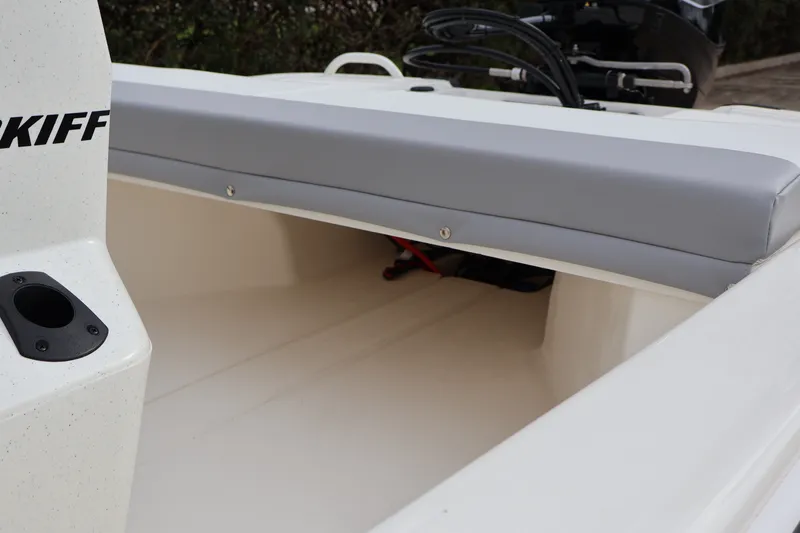 Slide: The Image of 2026 Mako Pro Skiff 13 CC boat interior with cushioned seating and storage area. - 15