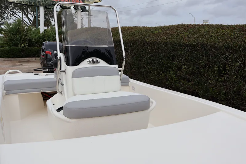 Slide: The Image of 2026 Mako Pro Skiff 13 CC boat with console and seating, parked outdoors. - 6
