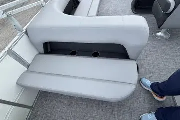 Slide: The Image of 2027 Sun Tracker Party Barge 18 DLX interior with gray seating and cup holders. - 15