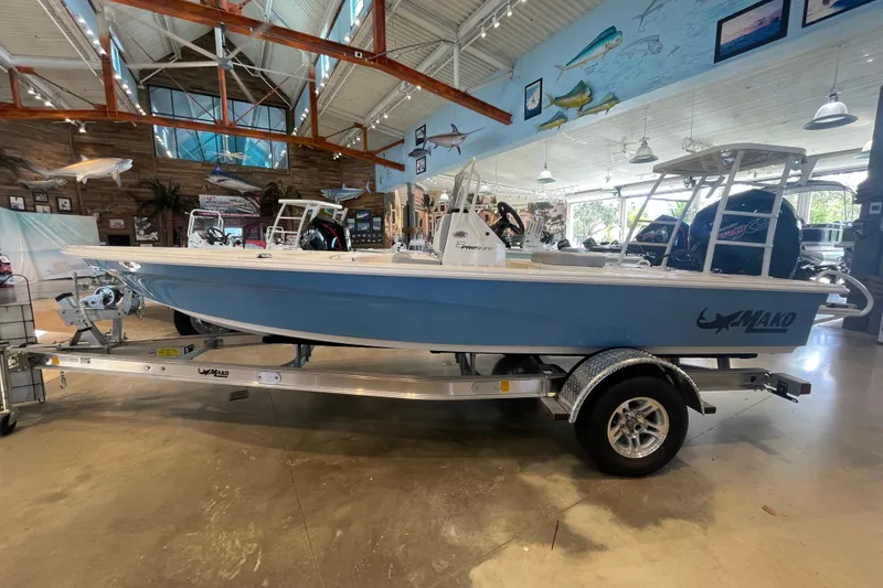 The Image of 2026 Mako 18 Pro Skiff boat displayed indoors on a trailer. - 0