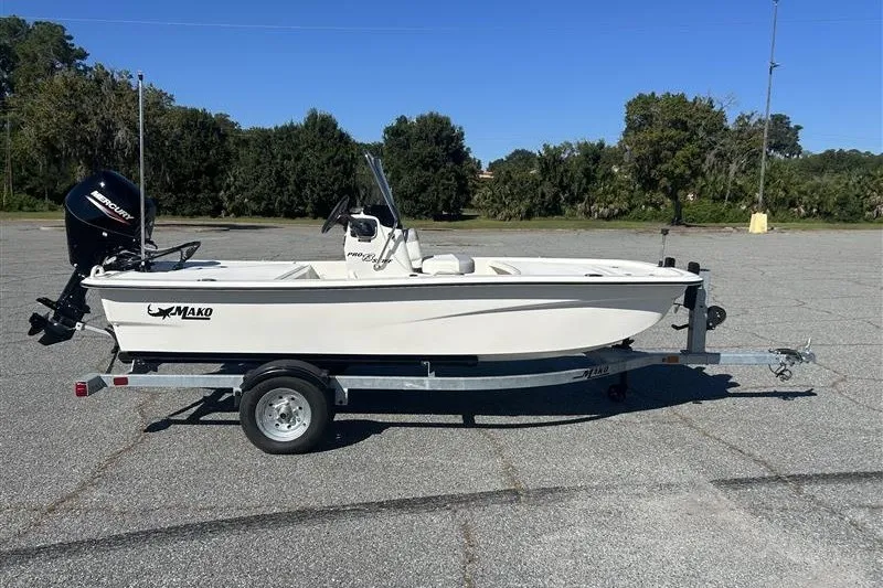 Slide: The Image of 2026 Mako Pro Skiff 13 CC boat on trailer in parking lot. - 1