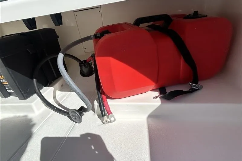 Slide: The Image of Red fuel tank and cables inside a 2026 Mako Pro Skiff 13 CC boat compartment. - 9