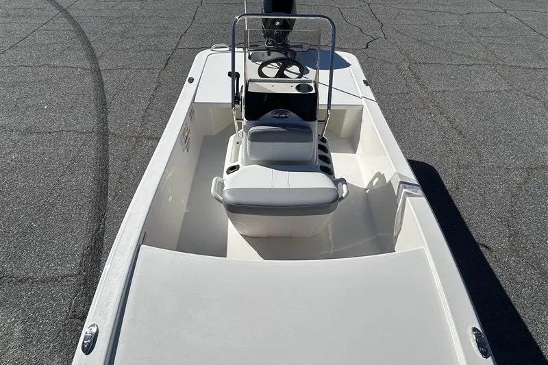 Slide: The Image of 2026 Mako Pro Skiff 13 CC boat, featuring a central console and seating, on pavement. - 4